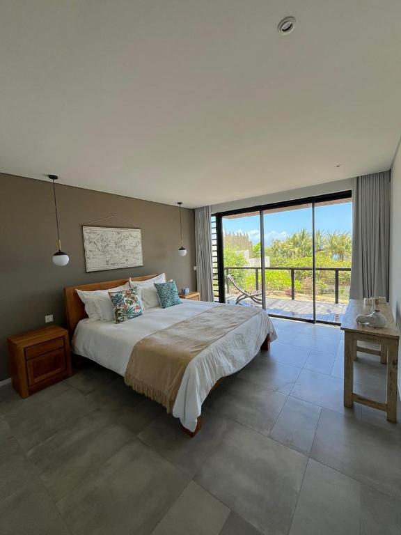 Chambre élégante avec accès direct au balcon et vue dégagée sur la nature environnante d'une villa 3 chambres à l'Île Maurice.