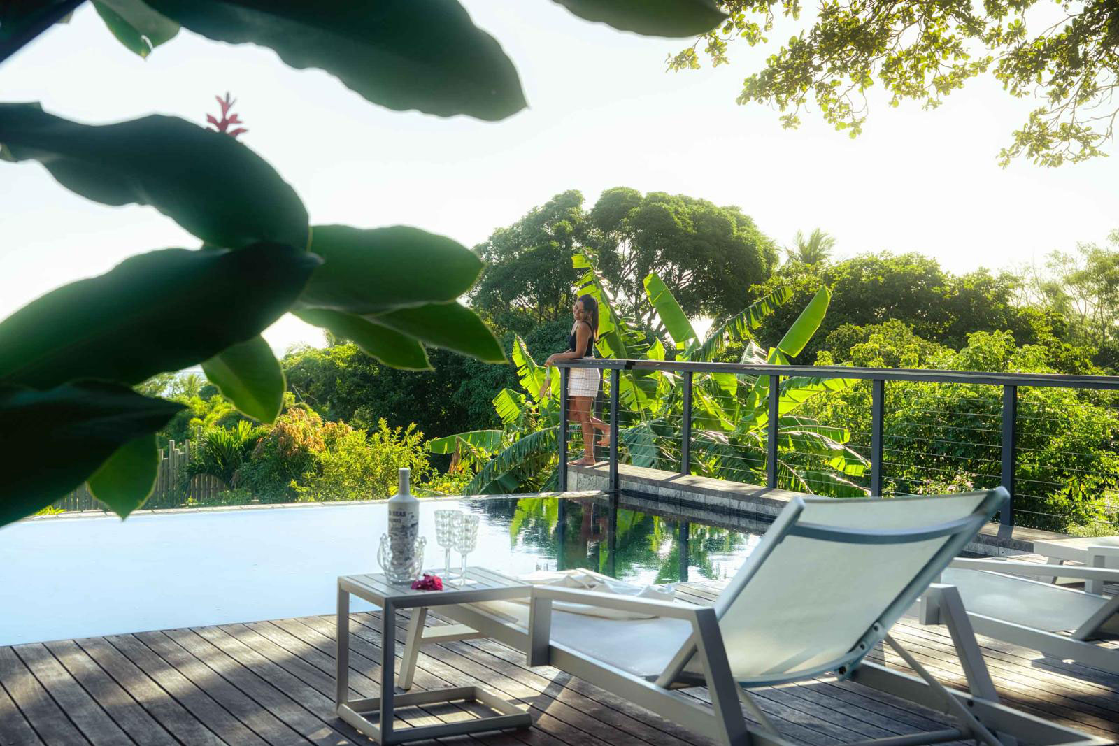Terrasse en bois aménagée avec chaises longues et piscine privée d'une villa de luxe 3 chambres à l'Île Maurice.
