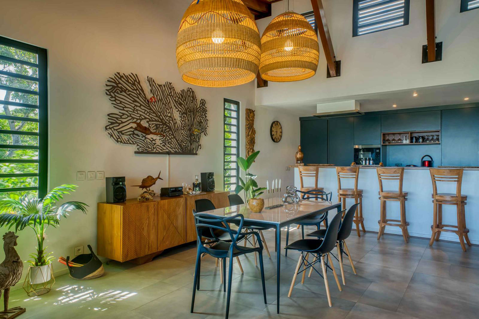 Salle à manger moderne avec luminaires en paille et décoration tropicale dans le séjour d'une villa 3 chambres à l'Île Maurice.