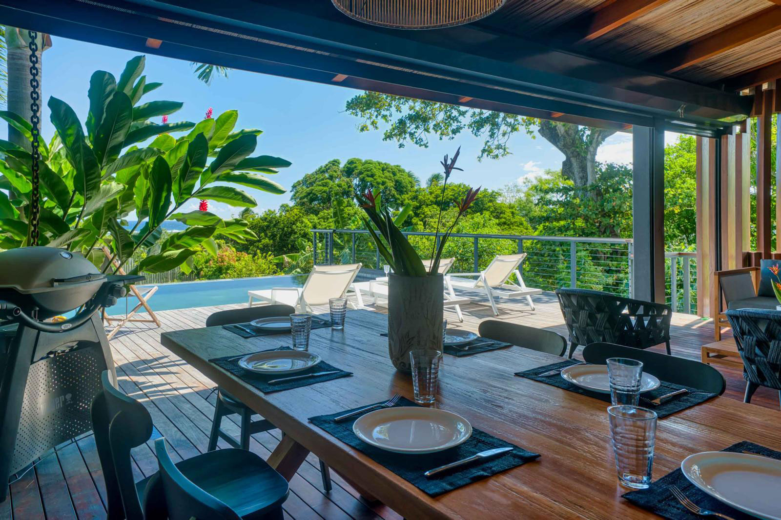 Terrasse en bois aménagée avec chaises longues et piscine privée d'une villa de luxe 3 chambres à l'Île Maurice.