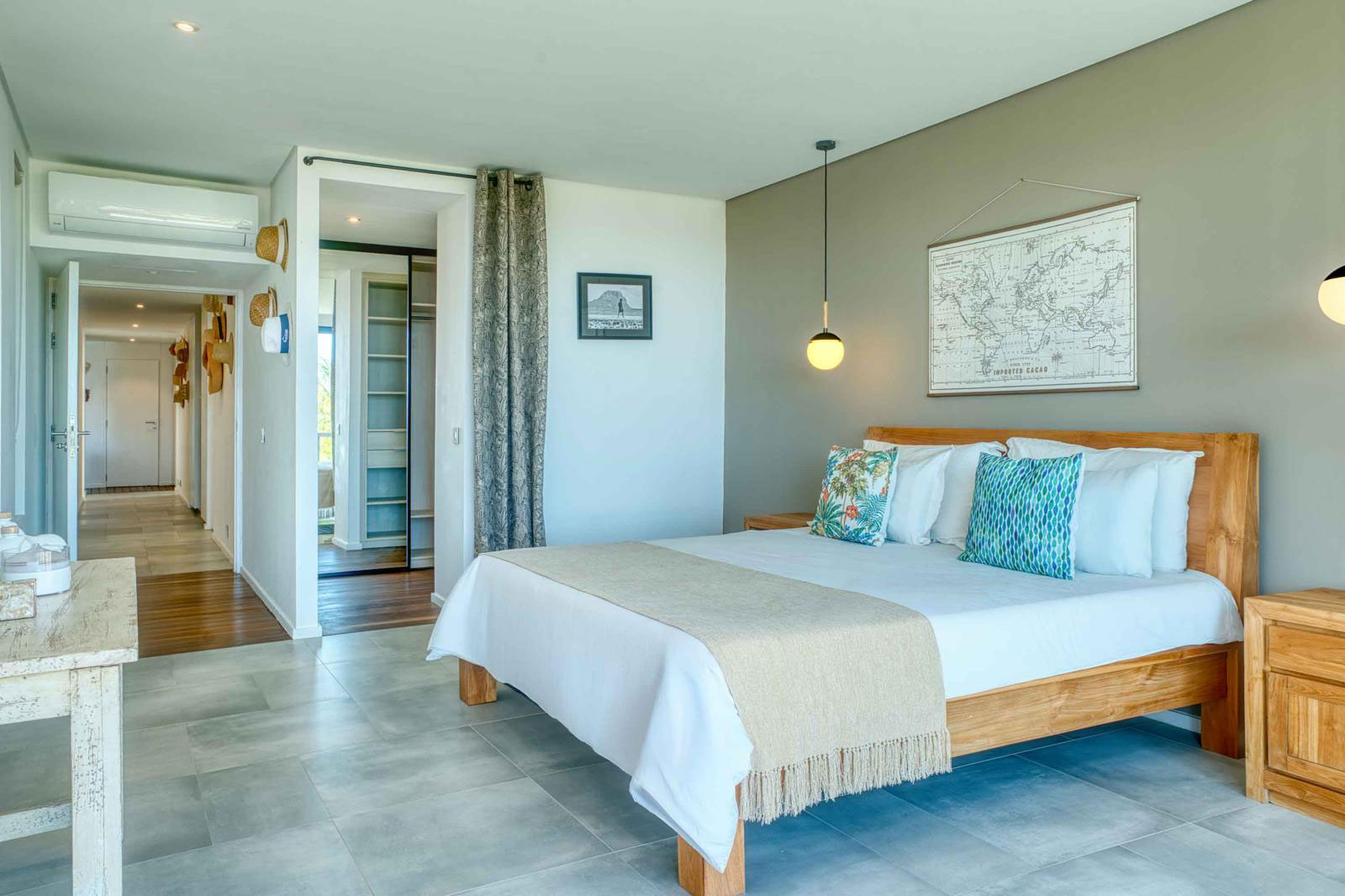 Chambre à coucher beige spacieuse, lit double en bois et large baie vitrée dans une villa 3 chambres à l'Île Maurice.